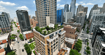 an aerial view of a tall building with a green roof